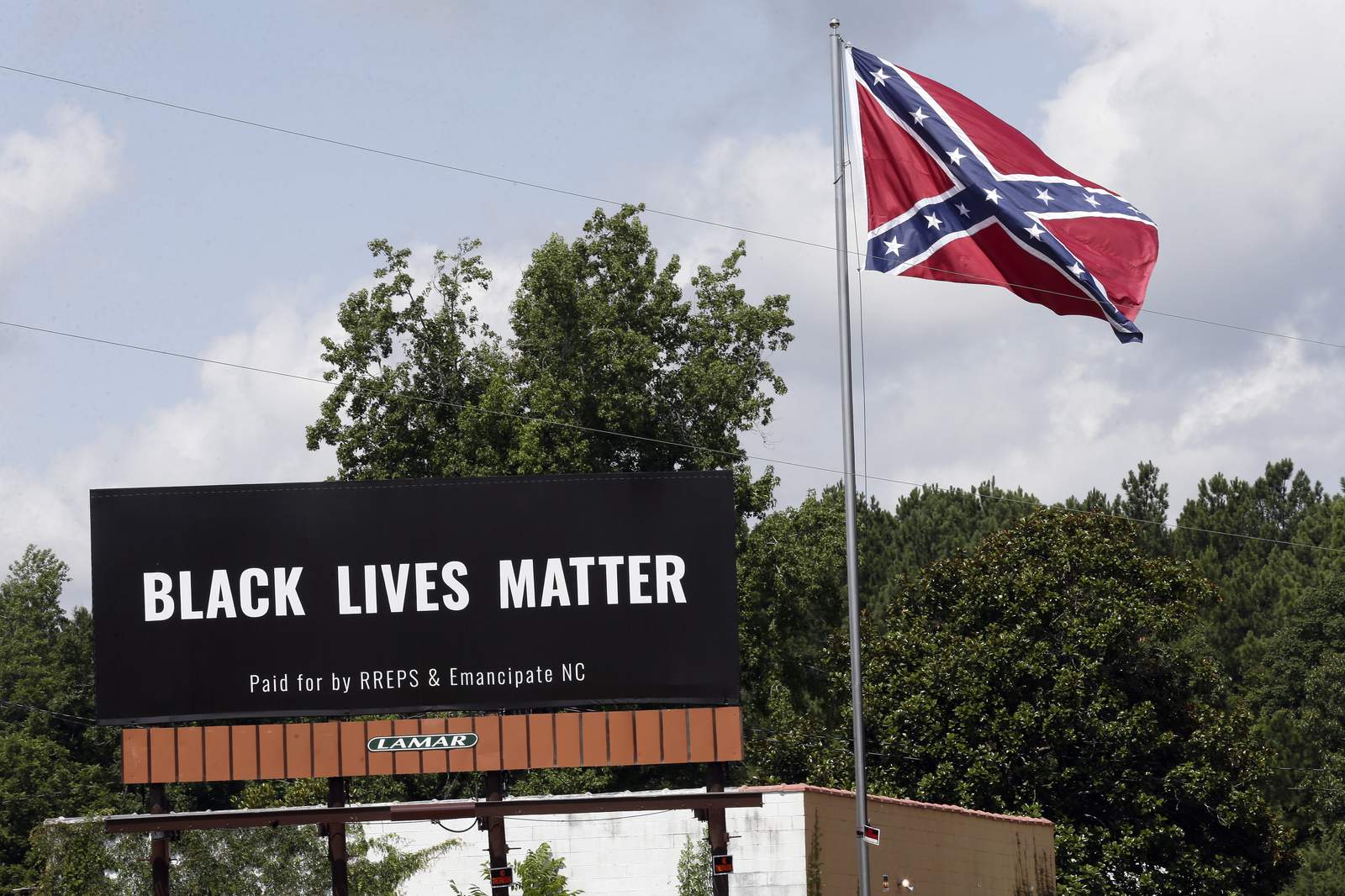 Black Lives Matter billboard placed next to Confederate flag