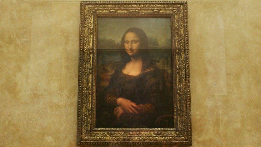 Man in wig throws cake at glass protecting Mona Lisa
